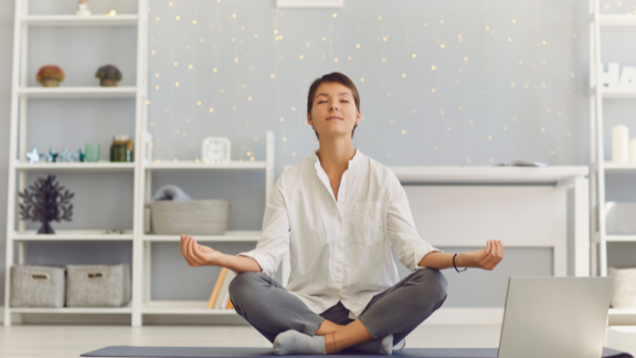 A woman is shown meditating.
