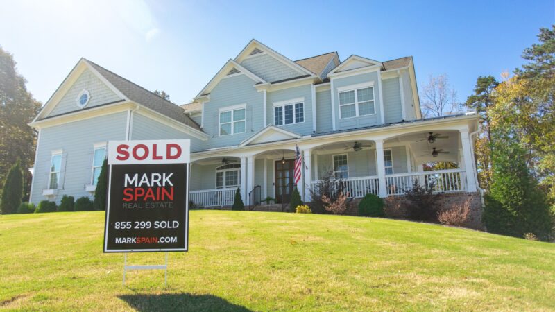 Blue house on a hill being sold with Mark Spain Real Estate after increasing the value of a home. 